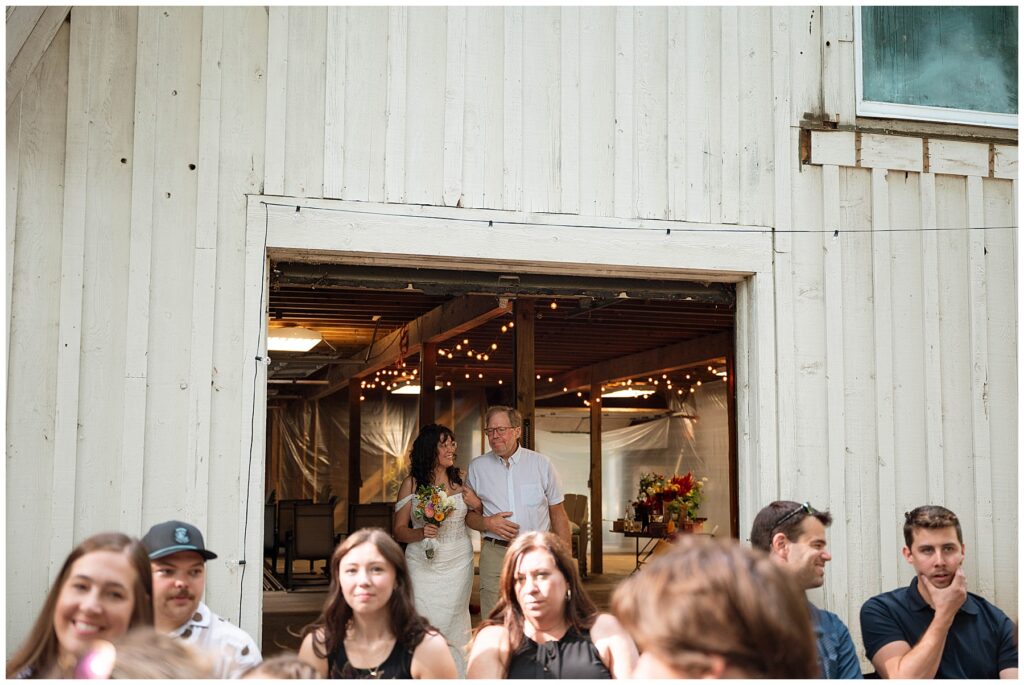 Bride anticipates walking down aisle on her wedding day with her father by her side.